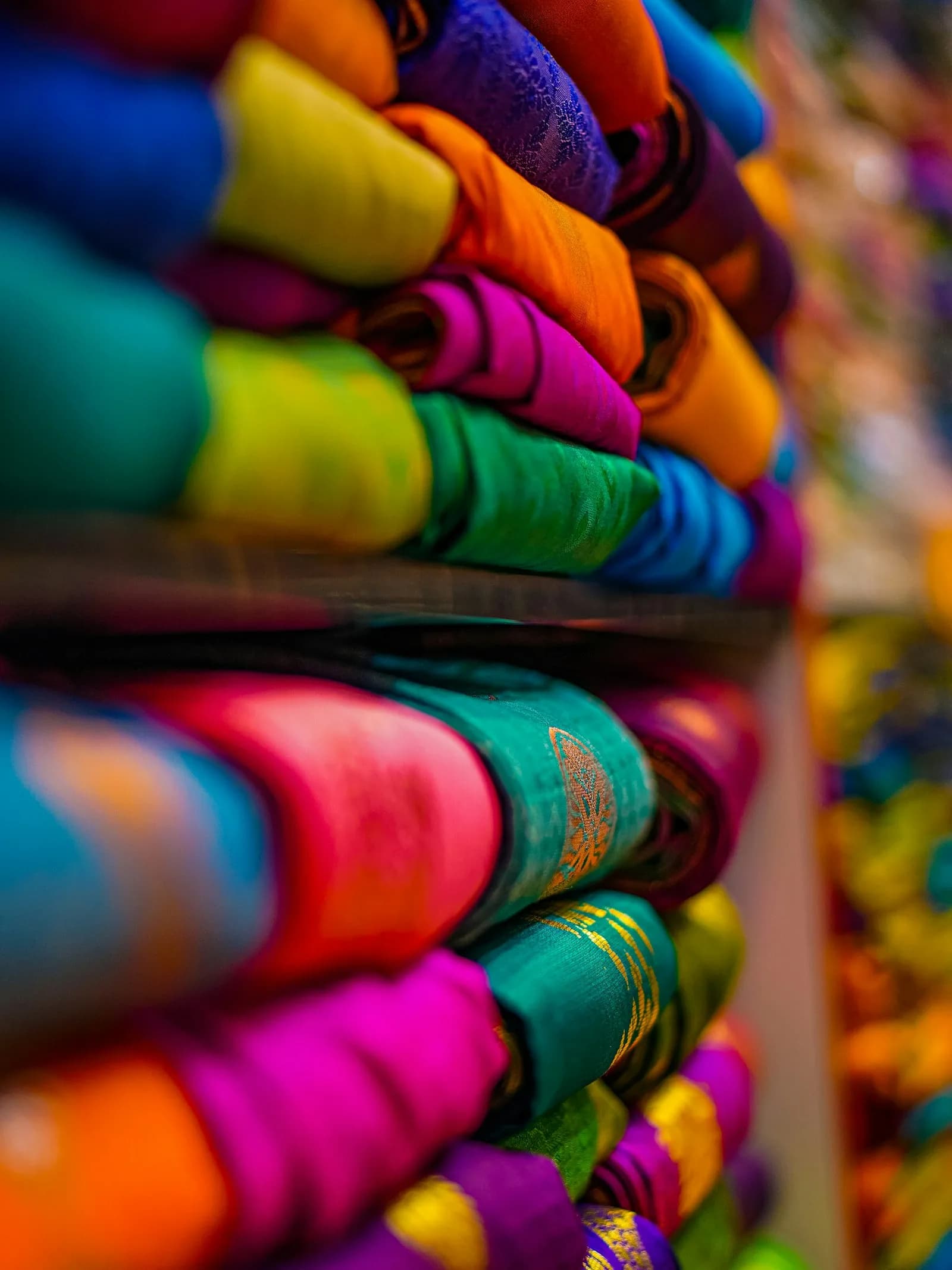 Colorful fabrics stacked on a shelf in the studio